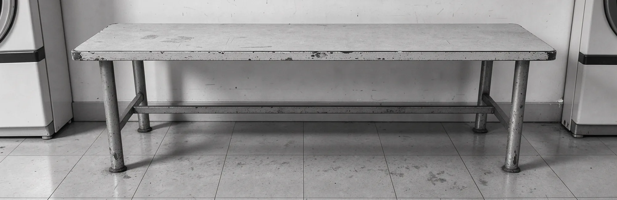 A plain empty bench in a shared laundrette.
